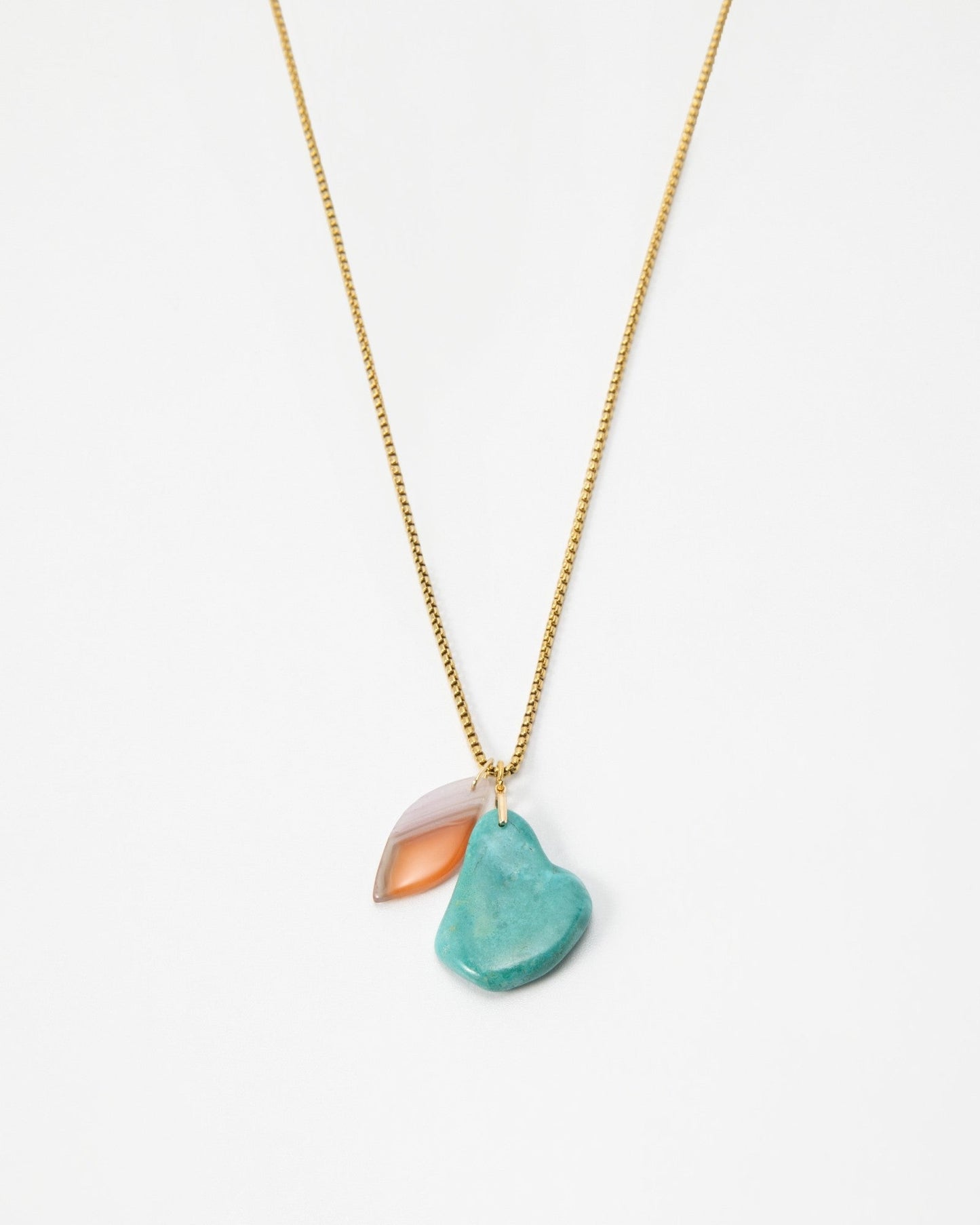 Elsita Jewelry Rusty III necklace featuring a gold chain with a turquoise stone and a translucent peach charm.