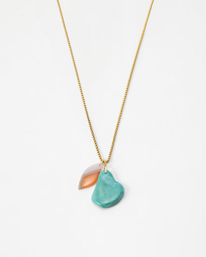 Elsita Jewelry Rusty III necklace featuring a gold chain with a turquoise stone and a translucent peach charm.