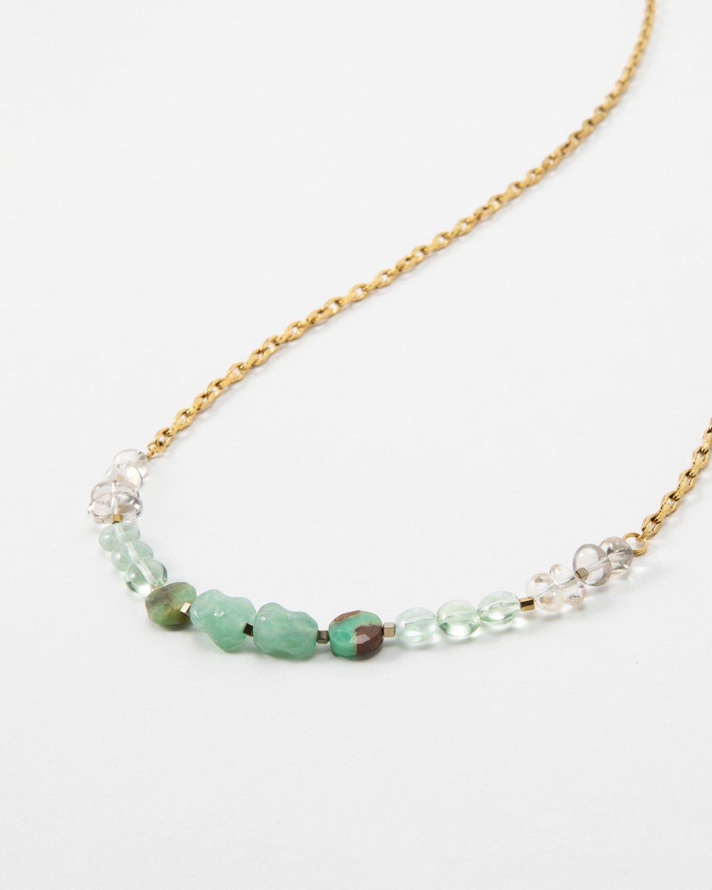 Elsita Jewelry Wandern necklace featuring a gold chain with green and clear gemstone beads on a white background.